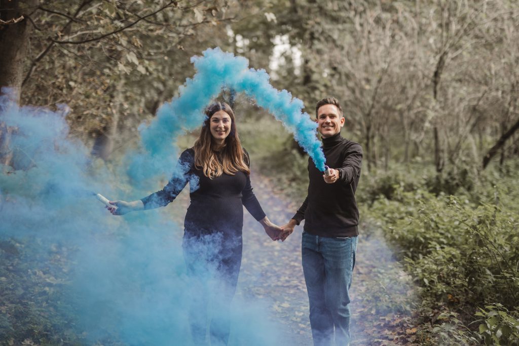 Ein Paar mit Babybauch haben eine Rauchbombe gezündet