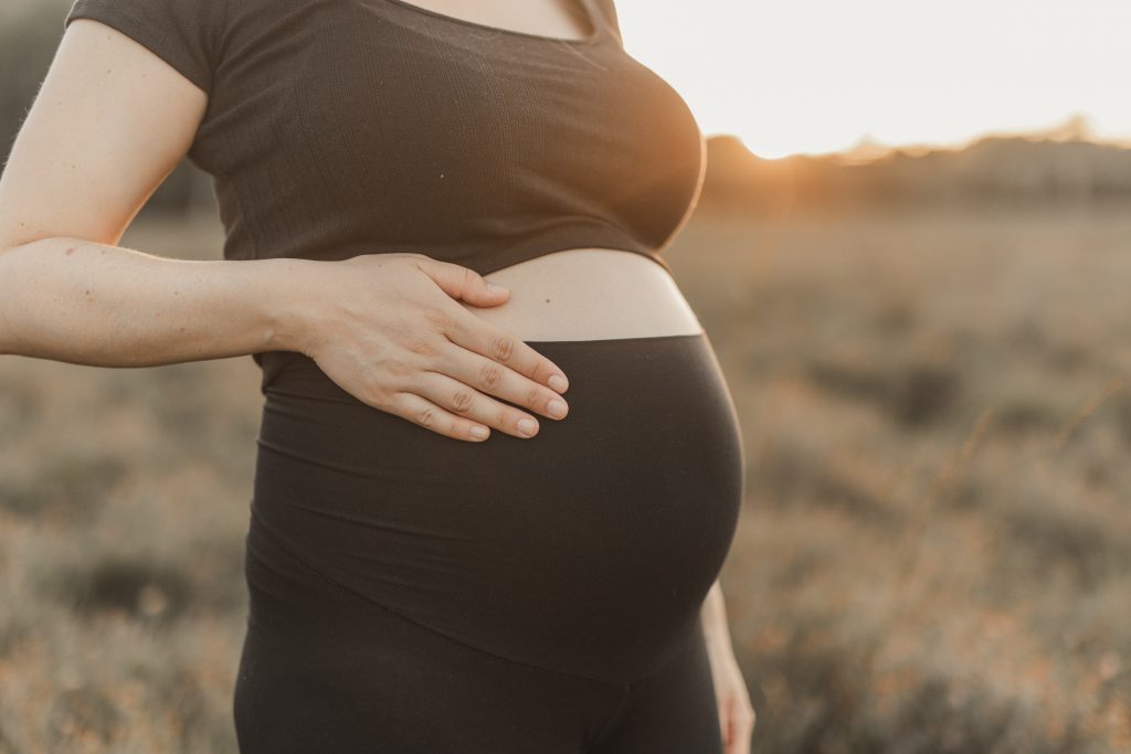 Detail eines Babybauch im Sonnenuntergang
